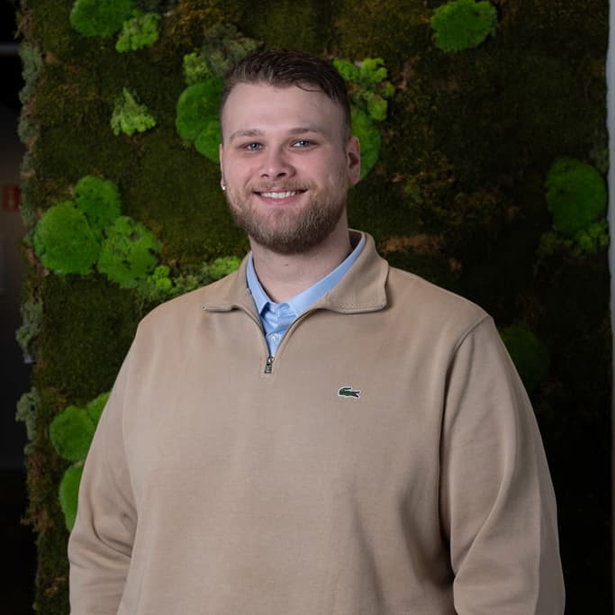 Thijs Molenaar portret in beige fleece tegen moswand